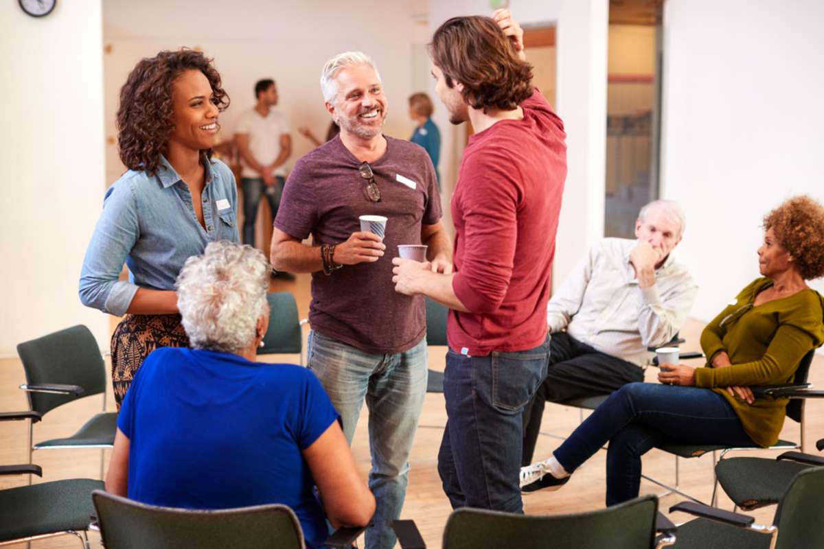 Group Of People Socializing After Meeting In Community Center