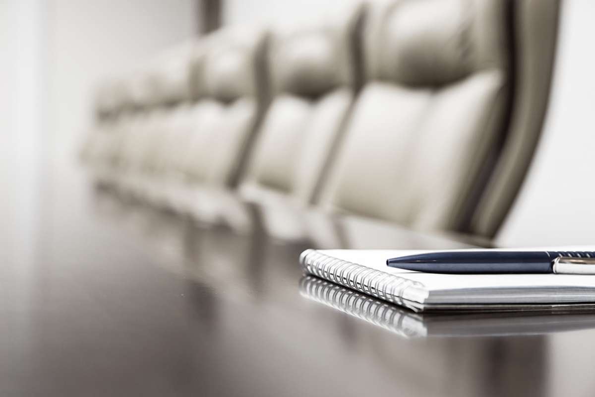 Closeup of notepad for agenda kept on table in empty corporate conference room